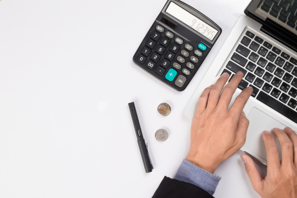 Person using laptop and calculator.