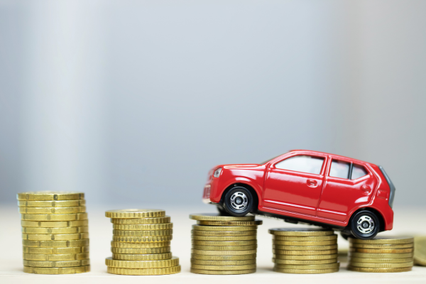 Red toy car on coins.