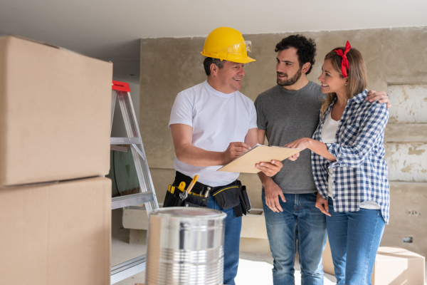Couple and contractor discussing plans about house remodel.