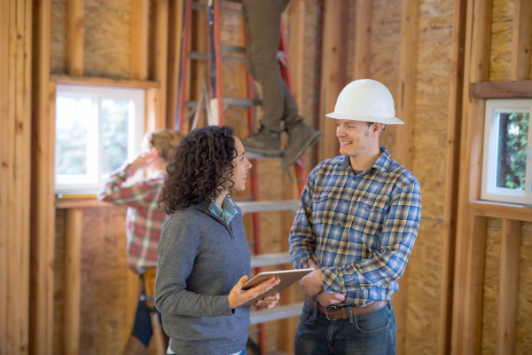 Man and woman working on house remodeling site.